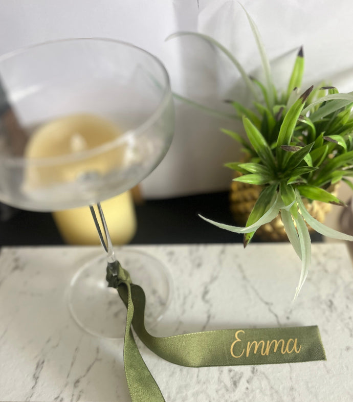 Personalised cotton green ribbon with gold font - tied in a knot around a wine glass